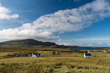 a view of Staffin village on the Isle of Skye with Quiraing Hills in the background.