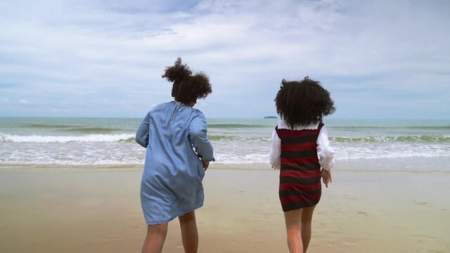 slow motion, african-American children  running on the beach in the summer
