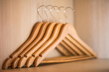 Clothing hangers on the brown wooden background.