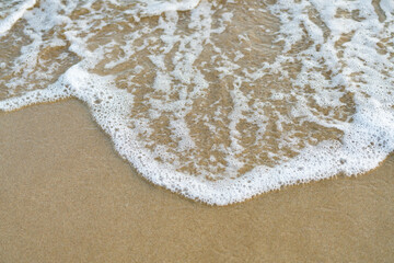 Beautiful soft waves of Blue Ocean with Sandy Beach Background close up. Sea sand wallpaper.