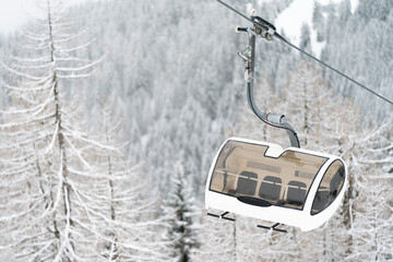 Ski Lift at Mountain Resort Flachau with Trees on foggy Day. Beautiful background with trees.