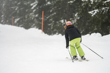 Woman with black and green sportswear skiing and are going to the mountains in winter. Austria Flachau.