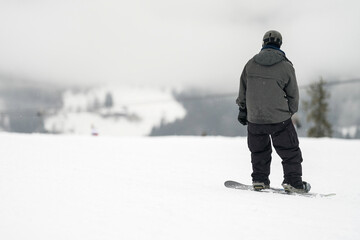 Unidentified tourist does snowboard skiing in Flachau, the ski resort in Austria. Man in black and...
