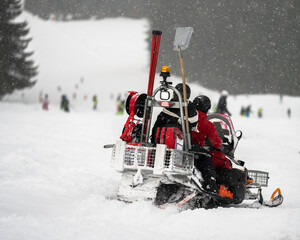 Ski patrol with snowmobile rescue in action on the ski slopes of Flachau in Austria