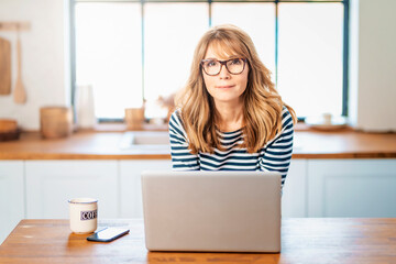 Happy woman using her laptop while working from home