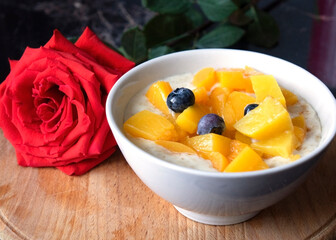 Oatmeal porridge with blueberries. Lovely breakfast with rose