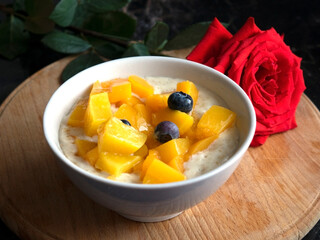 Oatmeal porridge with blueberries. Lovely breakfast with rose