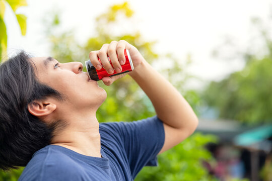 A Man Drinking The Famous Beverage Cola From Can