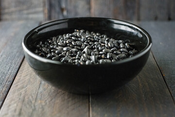 Black beans in black bowl and dark background