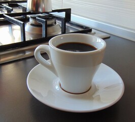 Moka coffee, in the foreground is a cup of coffee on the table, close-up, home kitchen.