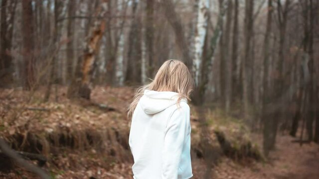Blonde walking in the woods. Young girl.