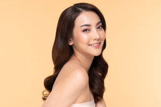 Wellness Asian young woman looking at camera clean fresh and nutural pure skin,Pretty girl smile with be moist skin on her face shining like a model,Facial treatment of beauty woman,isolated on Beige