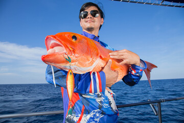 Lucky fisherman holding a beautiful goldfish