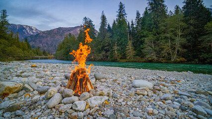Campfire on the river bank. Transparent river in the mountain forest. Skagit river loop trail,...