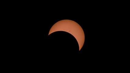 Partial solar eclipse. The Sun, Moon and Earth are aligned. The Moon blocks only part of the Sun's...