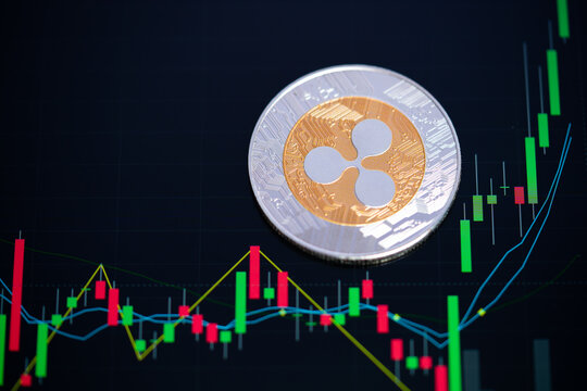 Ripple coin XRP cryptocurrency Golden and silver symbol and stock chart candlestick on tablets. Use technology cryptocurrency blockchain. with Capital Gain, Fundamental.