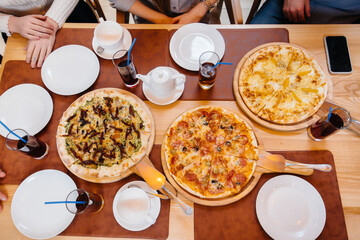 Delicious pizza close-up in a cafe during a friendly dinner.