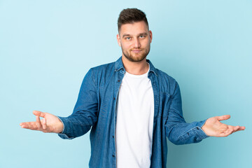 Russian handsome man isolated on blue background having doubts