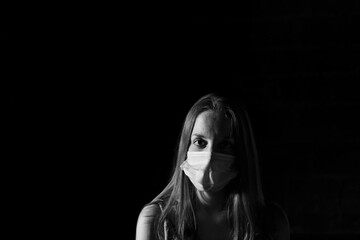 Portrait of a young girl with face mask and black background