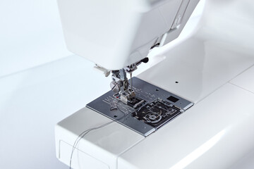 Sewing machine working part, replacement foot. Sewing machine with thread, closeup