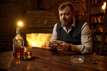 Man with guillotine cuts a cigar, tobacco smoking