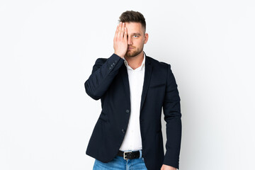 Young Russian business man isolated on white background covering a eye by hand