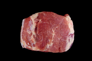 Overhead view of raw piece of pork isolated on black background. Piece of fresh boneless pork, neck part or collar. Big piece of red raw meat on a black background. 