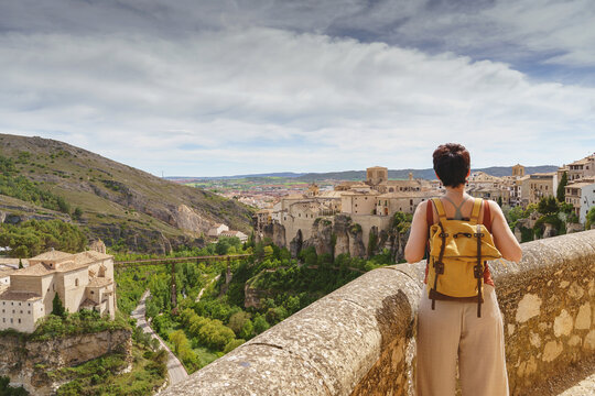 Horizontal view of unrecognizable woman with backpack on holidays looking at the ancient spanish city of Cuenca. Travel and holidays concept in european cities.