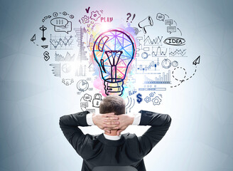 Businessman with hand behind head, lightbulb sketch doodle on blue wall