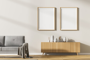 Living room interior with two empty white posters on wall, grey sofa oak wooden parquet floor,...