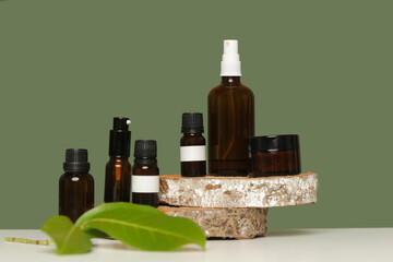 Various brown glass cosmetics bottles on green background	