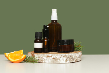 Various brown glass cosmetics bottles on green background	