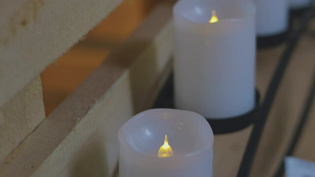 Close-up and selective focus 4K video of many plastic candle in a row with yellow light flickering as real candle for decoration in house shows clam and peace atmosphere for relaxing people.