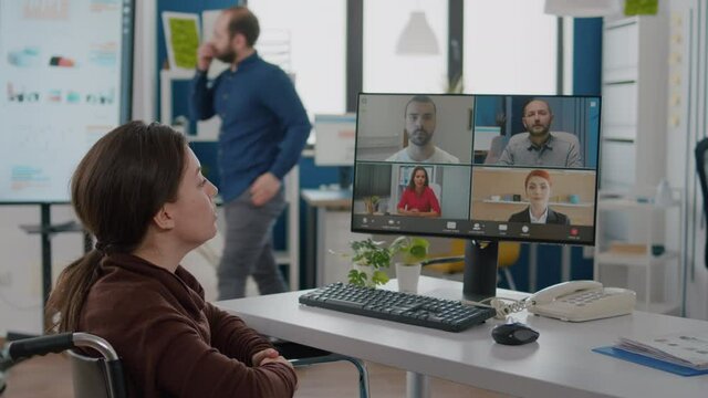 Handicapped paralyzed invalid employee during virtual meeting talking on videocall working from start up business office discussing with partners online using webcam. Businesswoman on video conference