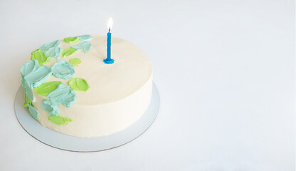 cake with green and blue abstract decor and one candle. copy space