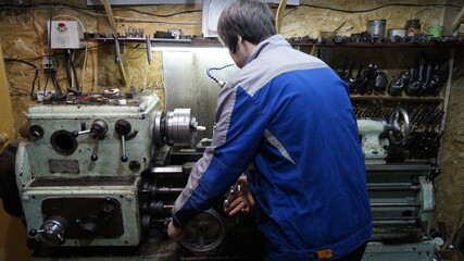 Turner behind a lathe in production