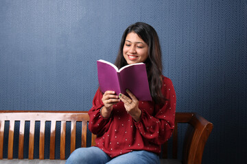 Young indian girl reading book or novel