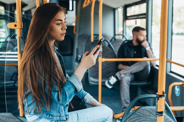 Woman using a smartphone while sitting in a riding bus