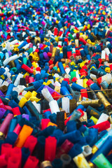 Many colorful spent shotgun shells displayed in front of a shooting range in the UK. Many different colors and gauges, concepts of clay shooting, war, conflict