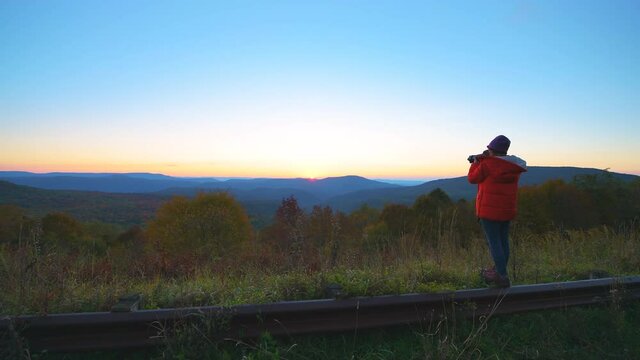 Pov point of view walking at West Virginia Monongahela national forest overlook with woman photographer taking photos of colorful autumn mountains at morning sunrise near Highland Scenic Highway
