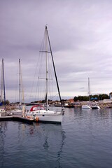 Naklejka premium Grand bateau à voile, voilier au port de bord de mer - tourisme vacances voyage - paysage urbain nuageux pluvieux pluie.