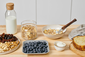 Wooden table with plates and bowls of food in the kitchen