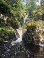 Lake District, rainbow over a beautiful natural waterfall.