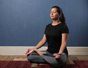 Smiling Indian woman practicing yoga at home. international yoga day
