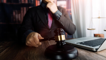 Justice and law concept.Male judge in a courtroom with the gavel, working with, computer and...