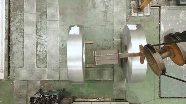 Aerial view of an Operator lifting a Steel coil with crane claw. Metal industry concept. High quality 4k footage