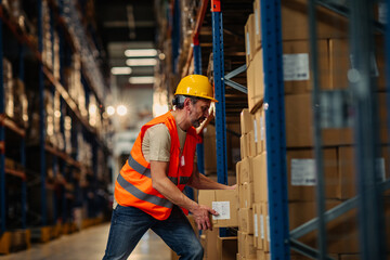 Worker stacks cardboard boxes at warehouse