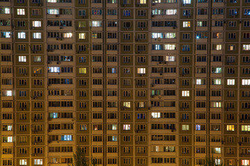 Fototapeta na wymiar Night windows of a high-rise building in the big city