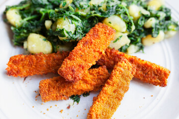 Fried fish sticks, crunchy and golden served with Swiss chard and boiled potatoes