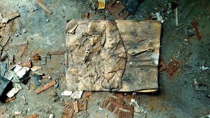 old burned and abandoned spell book lying on the dirty floor - dark literature background with...